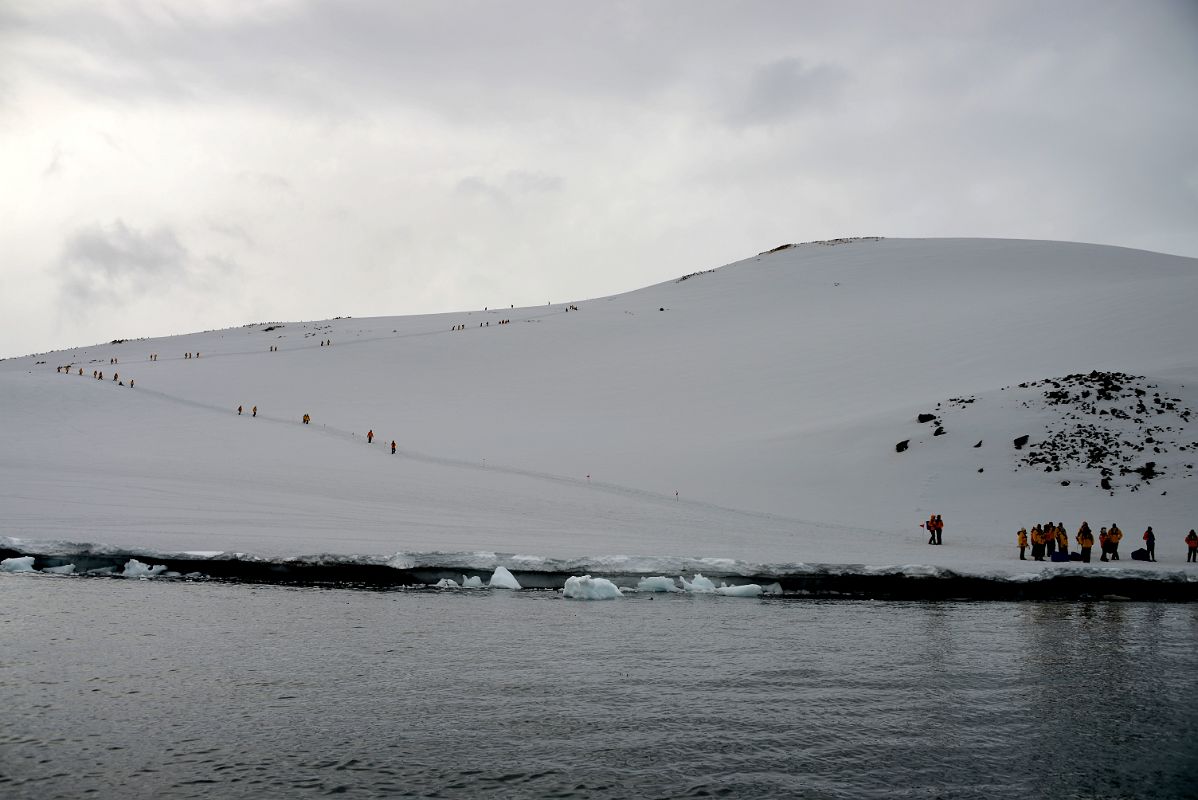 09C Zodiac About To Land On Danco Island With Tourists Climbing To The Top Of The Island On Quark Expeditions Antarctica Cruise